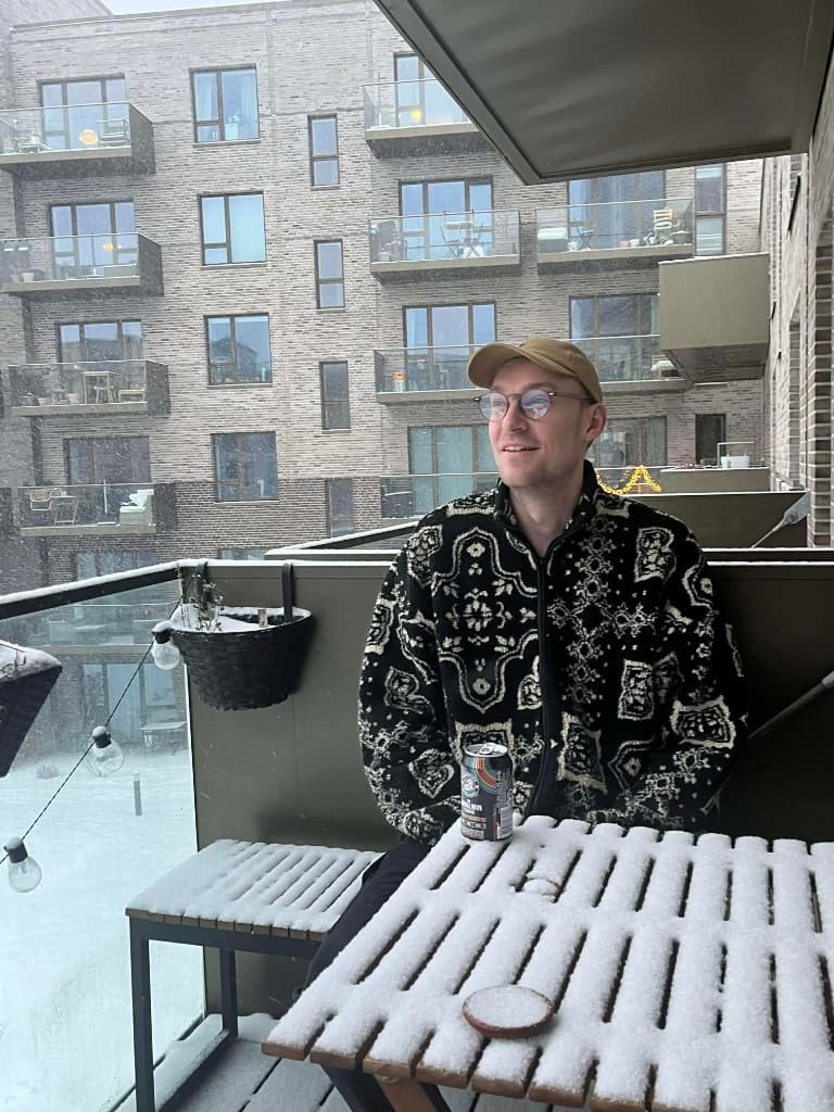 Kasper sidder på en snedækket altan